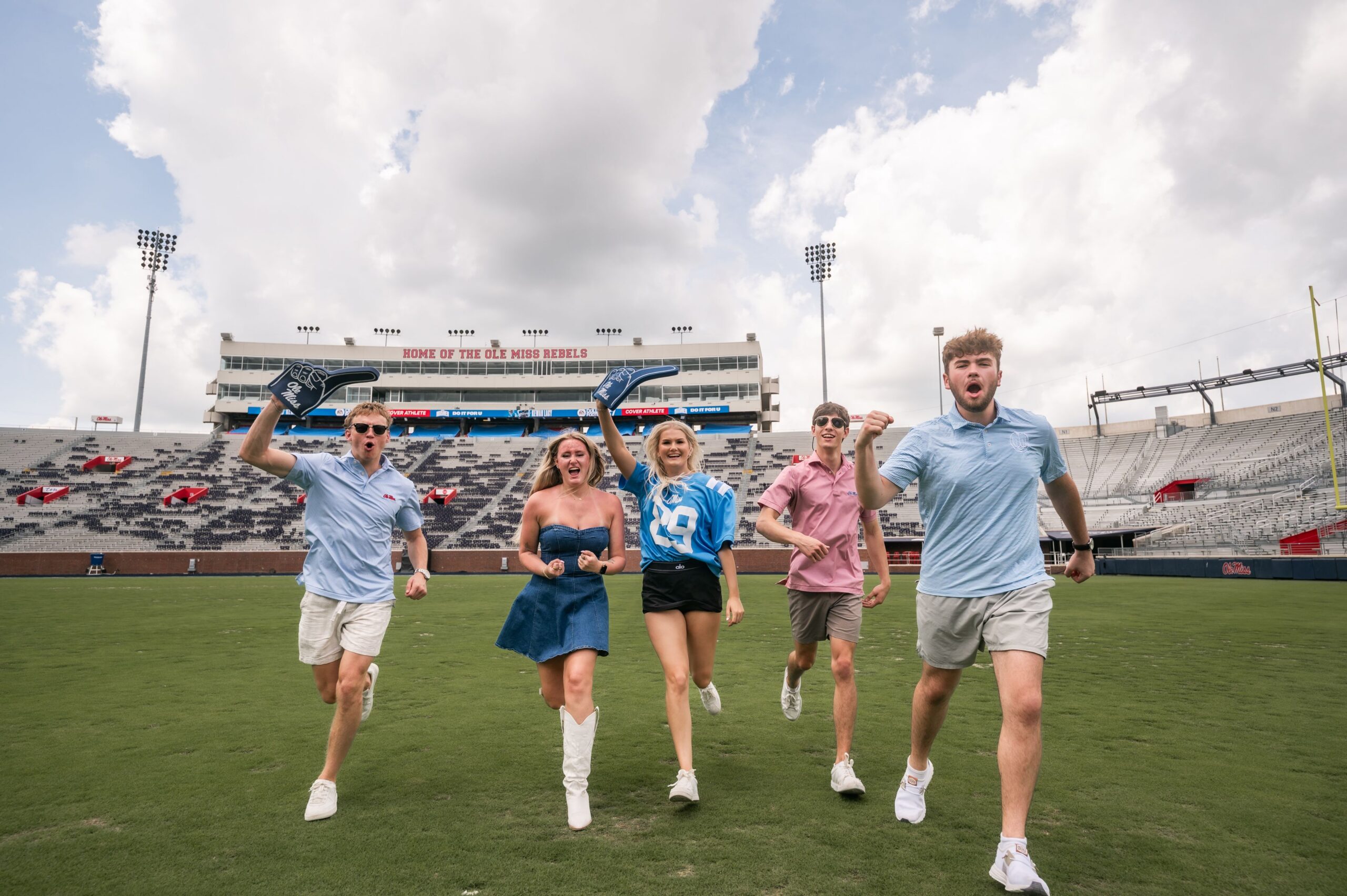 college fans celebrating on stadium field scaled