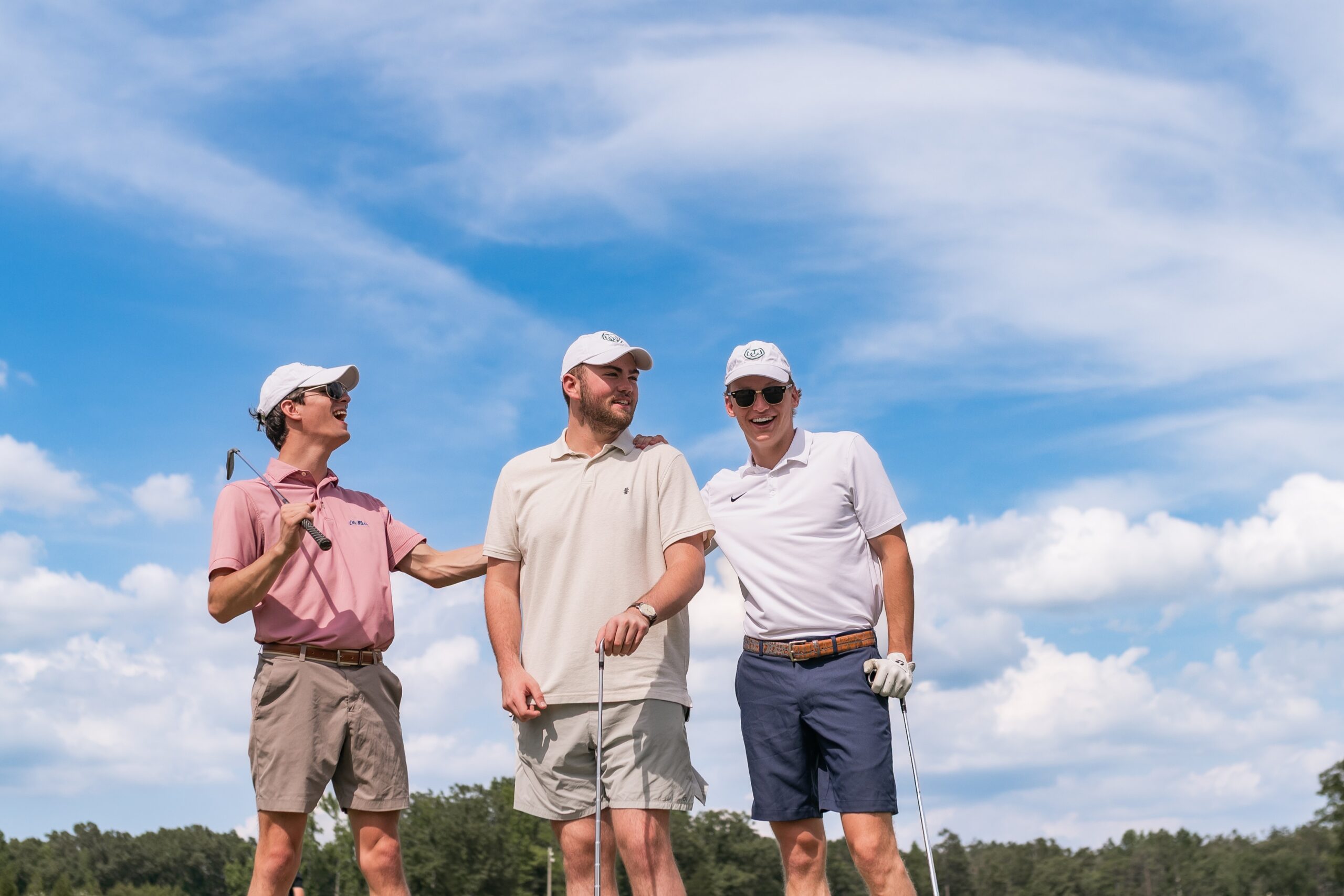 college friends posing on golf green scaled