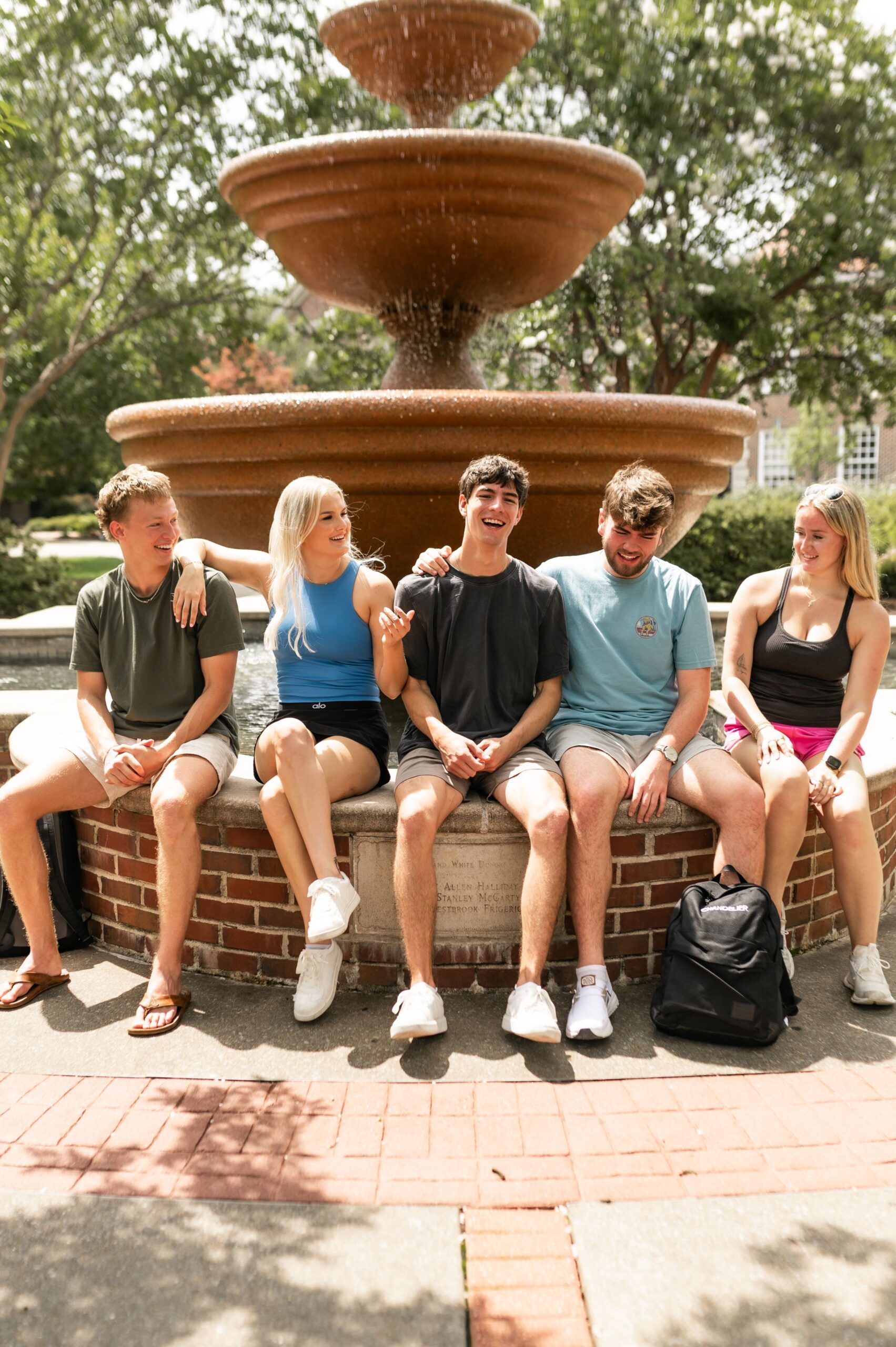 undergraduates gathered around campus fountain scaled