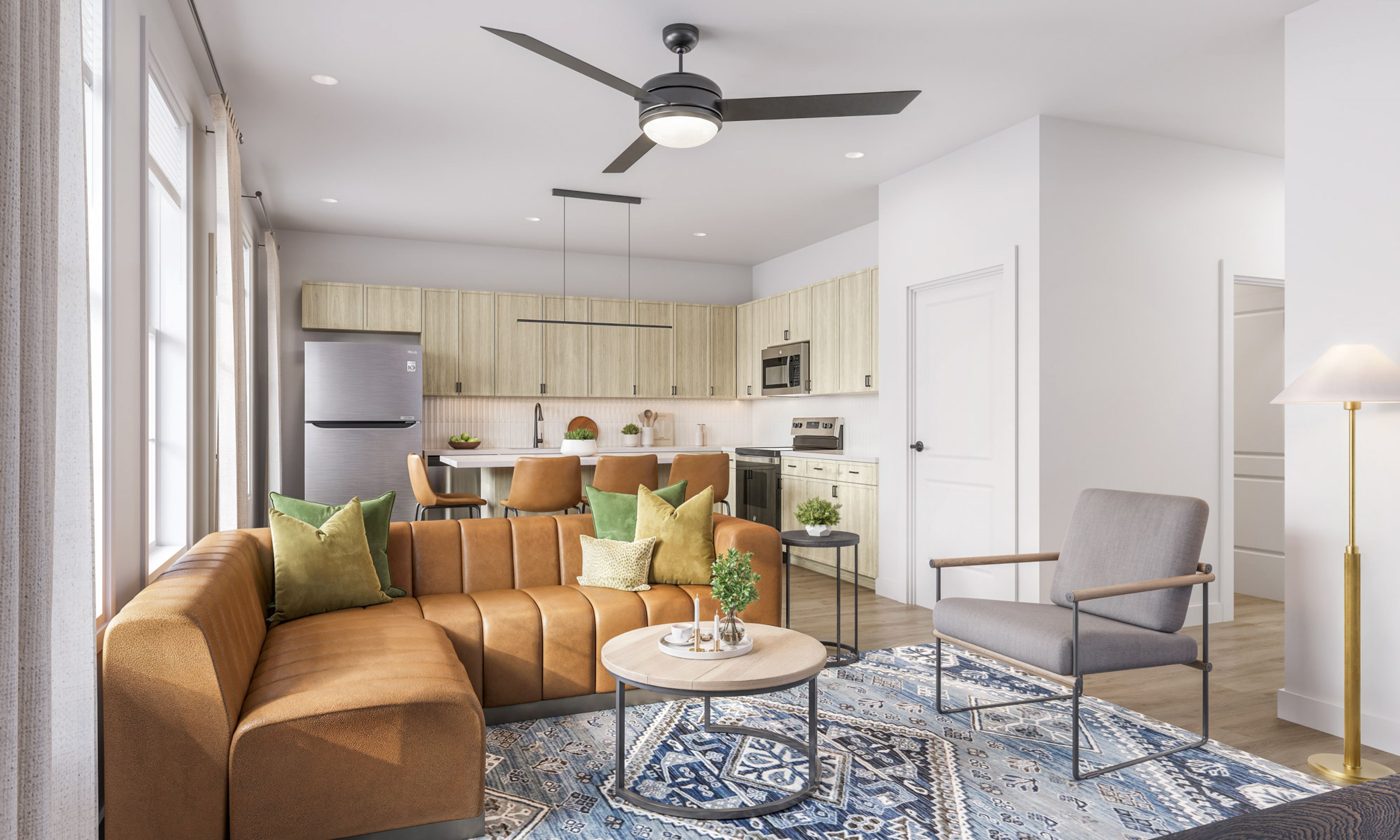 Chandelier Student Living Apartments Modern living room with brown sectional sofa, accent chairs, round coffee table, and open kitchen in the background.